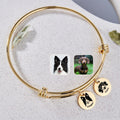 18K gold pet photo disc wire bracelet with two engraved pet portrait disc charms on a speckled tray