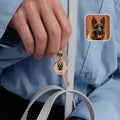 18k yellow gold pet face keychain held in hand showing portrait detail