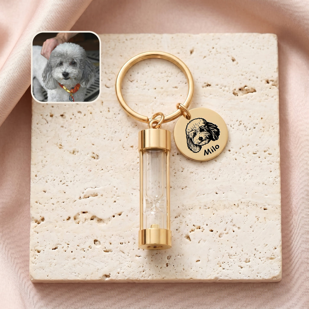 18k gold-plated pet portrait hourglass keychain on travertine stone with engraved poodle portrait disc and glass hourglass urn, with reference photo inset