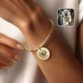18K gold-plated pet photo cuff bracelet with hand-drawn portrait disc charm, worn on a wrist beside an inset dog photo