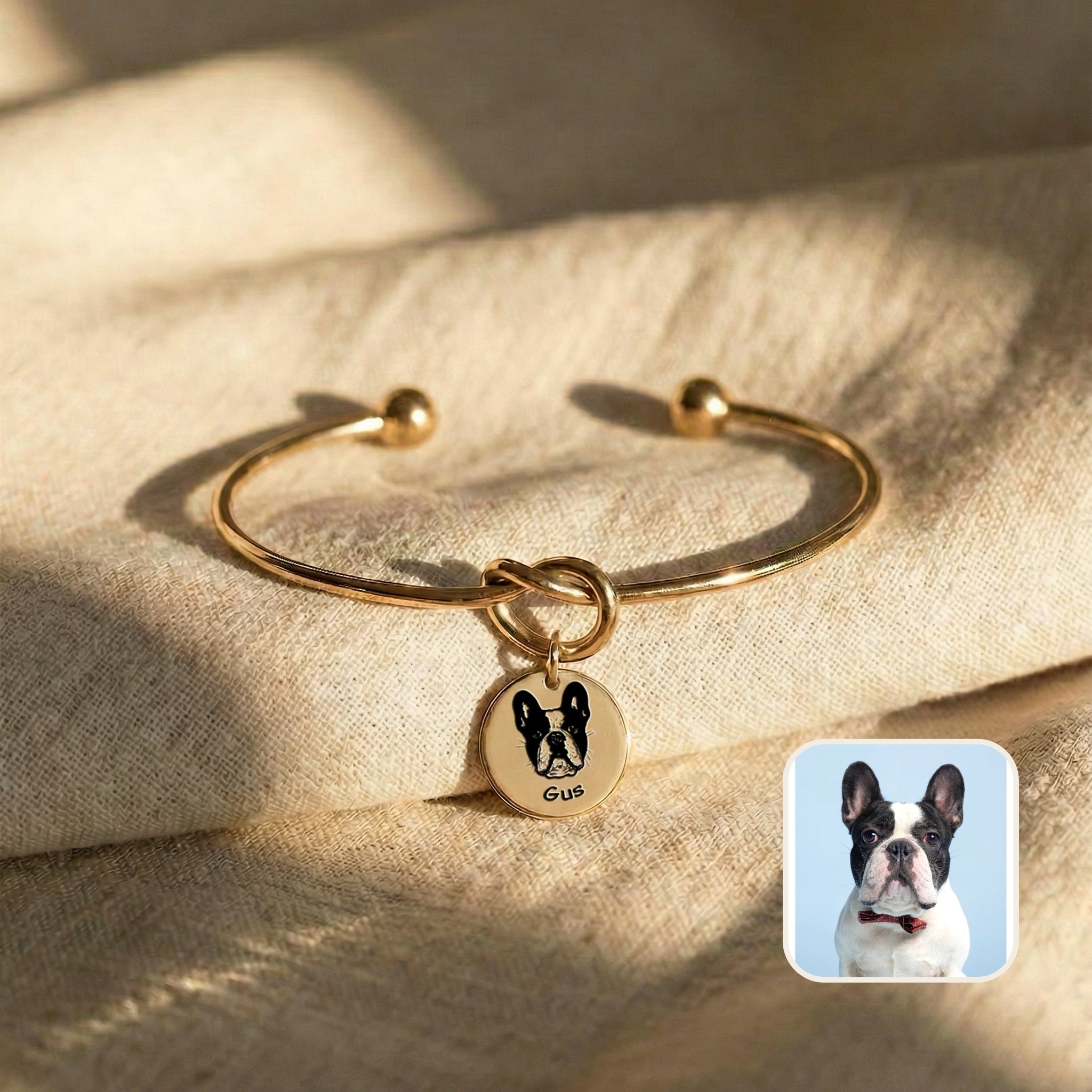 Gold knot cuff bracelet with engraved French bulldog portrait disc charm on cream fabric, beside the source pet photo