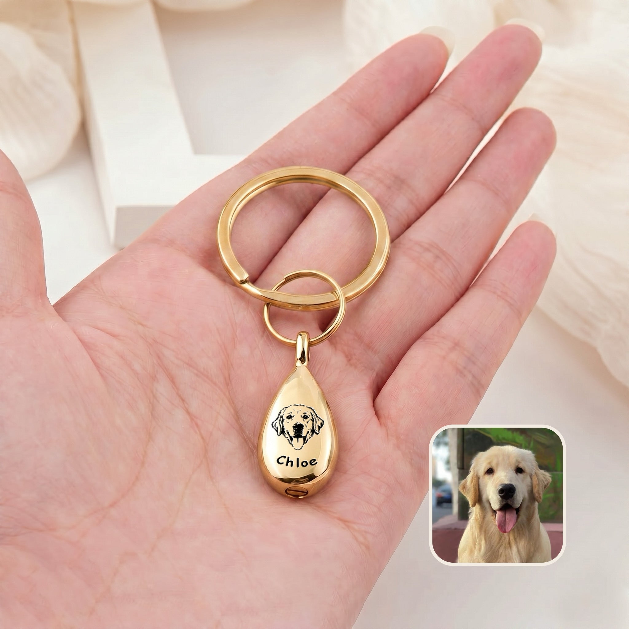 18k gold-plated pet portrait ashes teardrop keychain held in an open hand for scale, with a dog reference photo inset