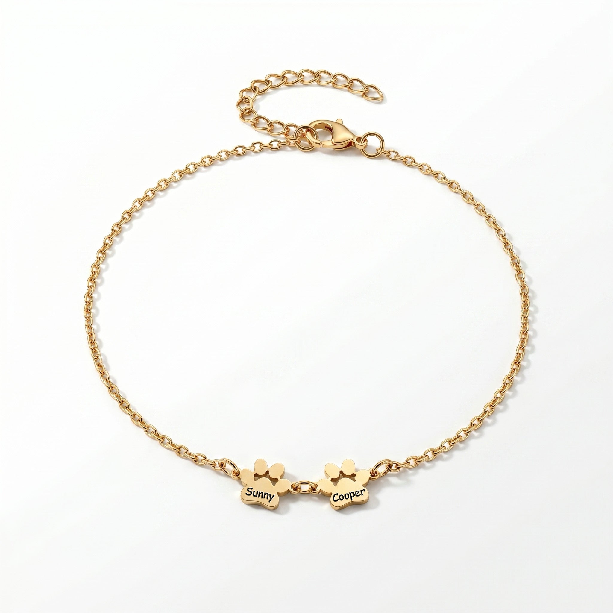Gold paw print name bracelet with two engraved charms on a plain white background