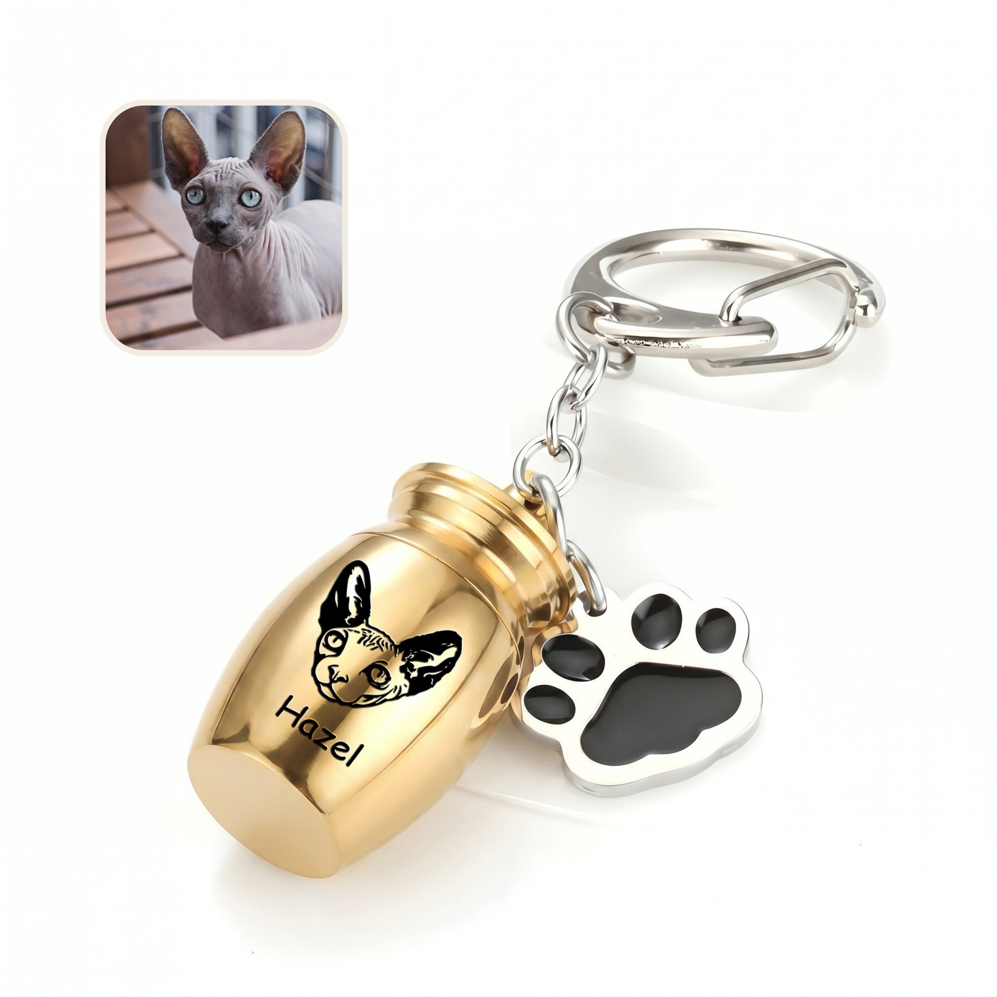 Angled 18k yellow gold pet urn keychain close-up on a clean white surface with a cat reference photo inset, showing the hand-drawn portrait engraving on the capsule face