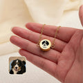 Yellow gold pet photo locket bracelet with hand-drawn dog portrait, shown across an open palm