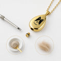 Gold teardrop pet urn necklace screw cap detail with ashes and funnel on white background